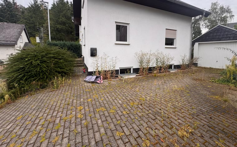 Hoffläche mit Bewuchs zwischen den Pflastersteinen vor dem Einsatz